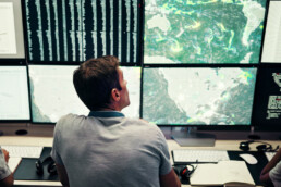 Man analyzing geospatial weather maps to assess conditions in environmentally harsh areas.